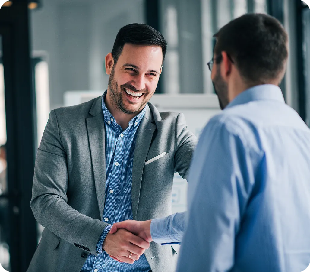 Two men shaking hands in an office.