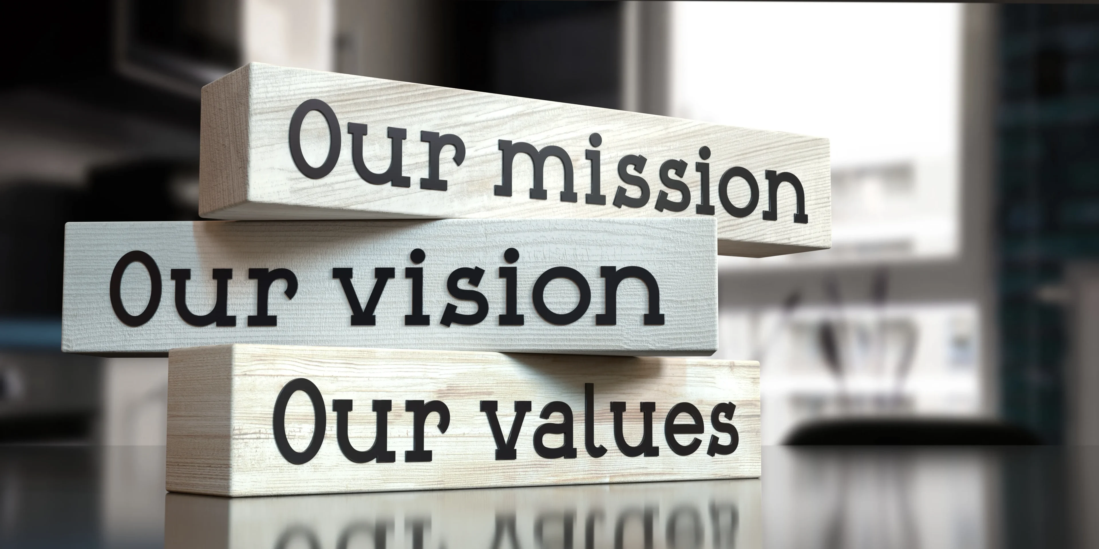 Mission, vision, values blocks on table.